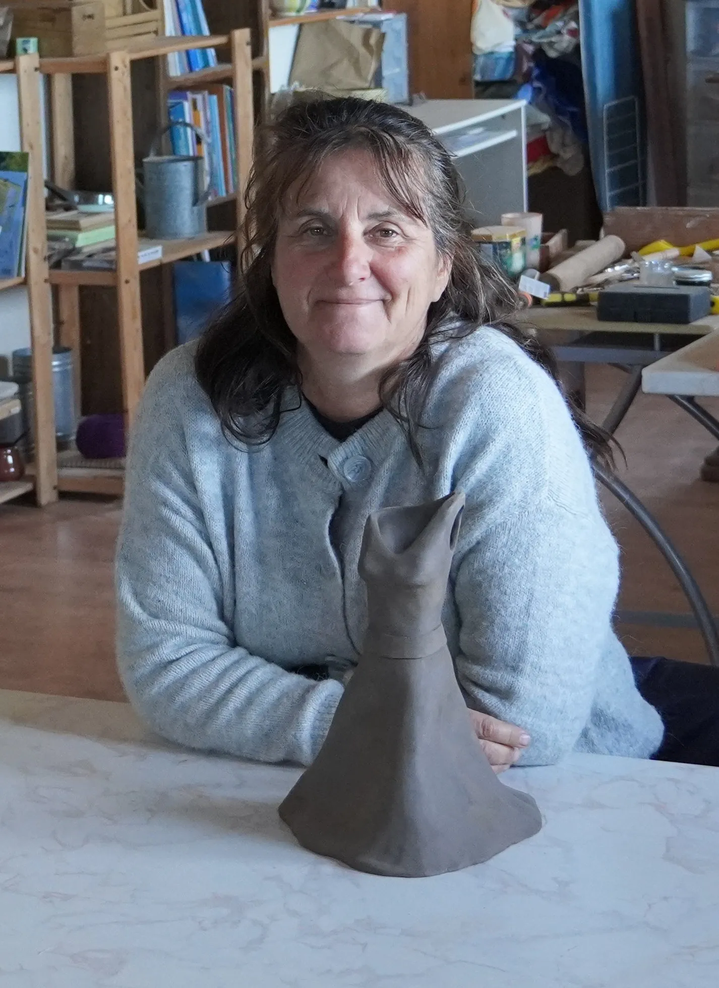 Christine en train de modeler une poterie sur sa table de jardin